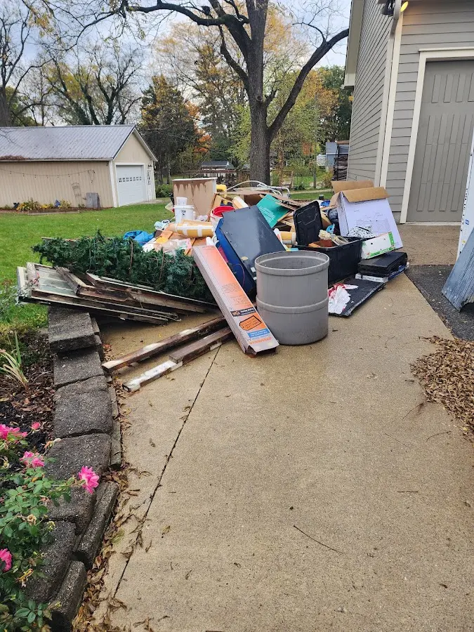 Dumpster being loaded with debris for 12 Yard Dumpster Rental in New Hope